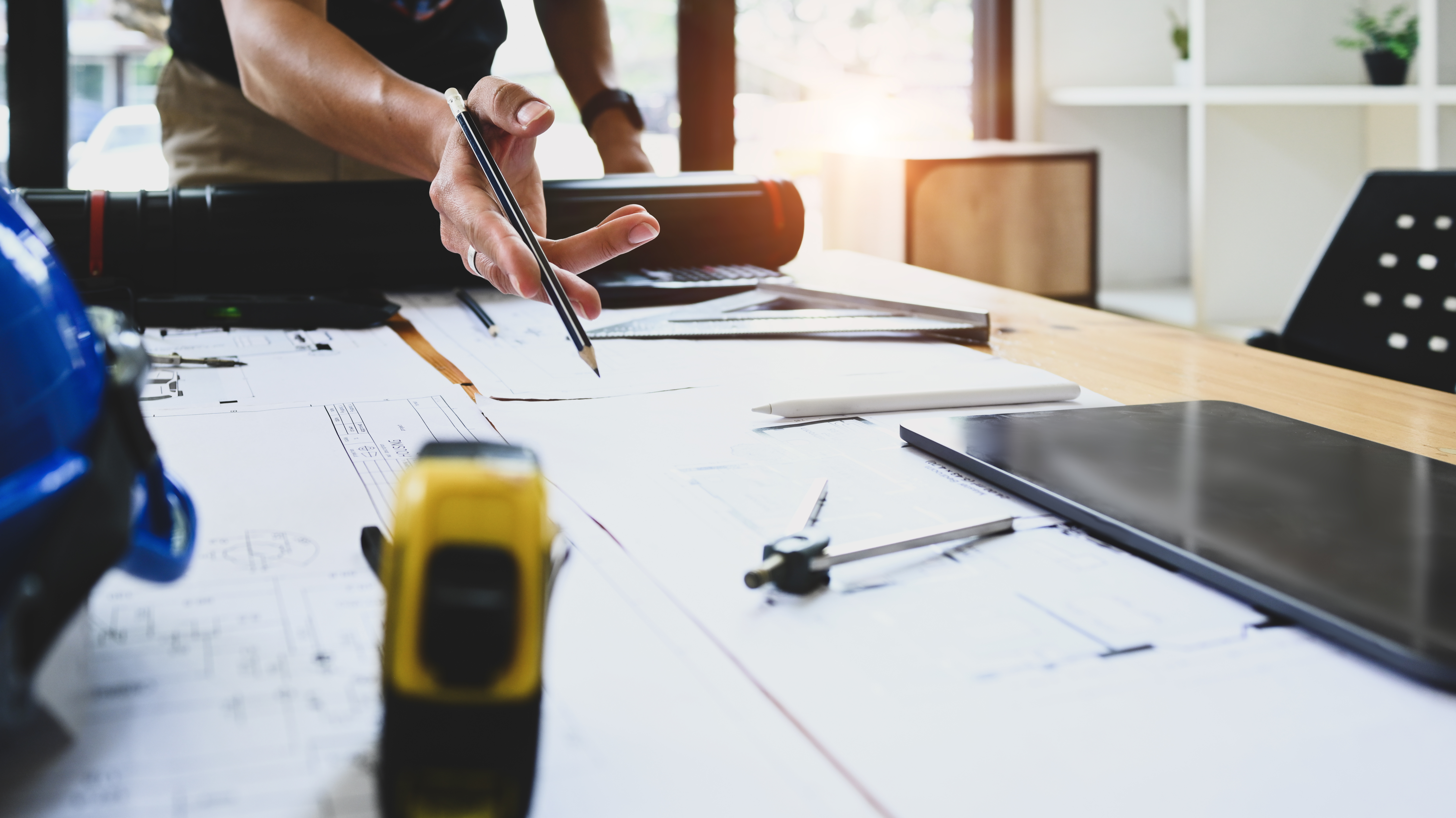 Cropped image of architect man pointing at blueprint, working on construction plan at office