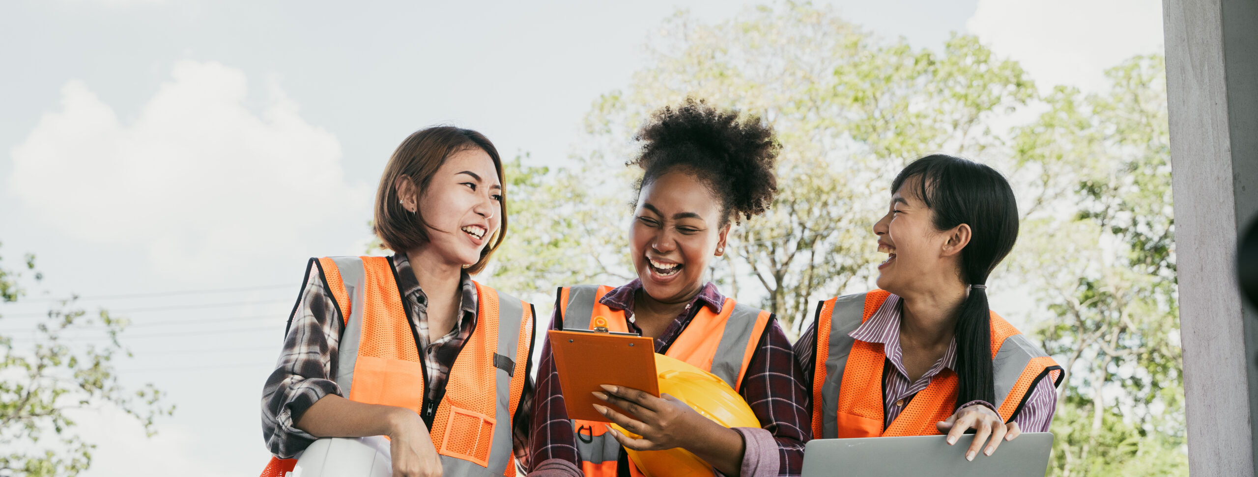 Group of happy cheerful multi ethnic engineers or construction workers at construction site having fun laughing in break time, team work concept.collaboration of Asians and African American.Tablet.